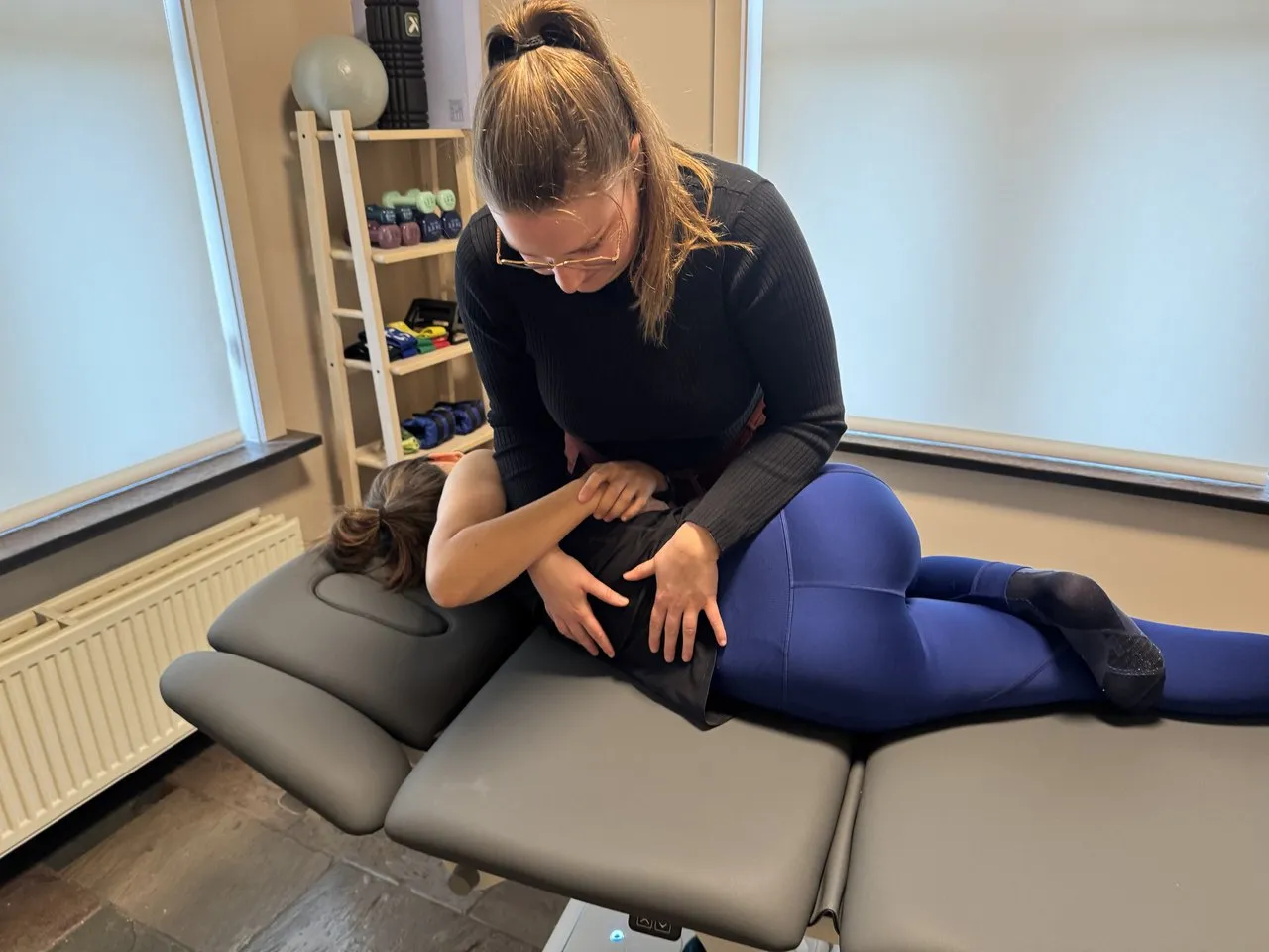 Margaux mobiliseert de rug van een patiënt op de behandeltafel